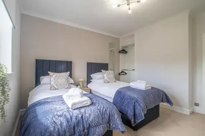 a bedroom with two beds with towels on them at Leven Loft - 2 Bed Flat in Coatbridge in Coatbridge