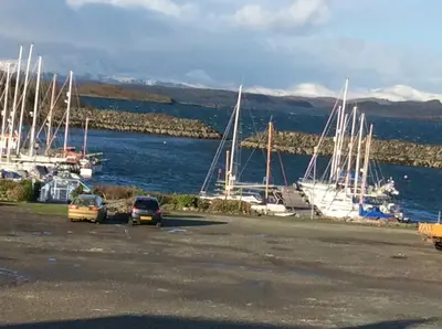 a group of cars parked in a parking lot near a marina at Morvern Cottage in Craobh Haven
