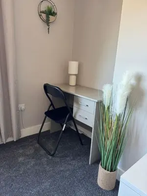 a desk with a chair and a plant in a room at 3 bedroom Falkirk flat in Falkirk