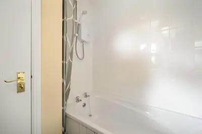 a white bathroom with a tub and a shower at Glasgow Apartment near Hydro & SECC, Finnieston in Glasgow