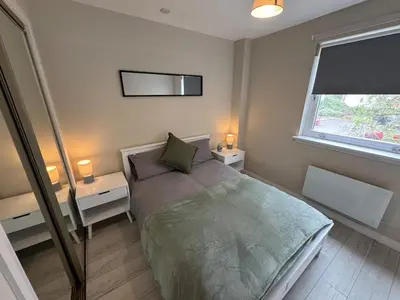a bedroom with a bed and two tables and a window at Newly Renovated Flat Edinburgh - 2 x Double Beds in Edinburgh