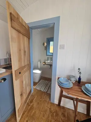 a small kitchen with a table and a bathroom at Wee Haven in Inverkeithing