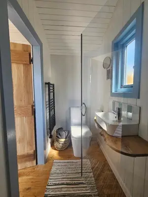 a bathroom with a toilet and a sink and a window at Wee Haven in Inverkeithing