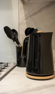a black appliance sitting on top of a kitchen counter at Curtis Apartment in Glasgow