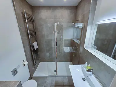 a bathroom with a shower and a toilet and a sink at Balmory Stables South - luxury stable conversion in Ascog