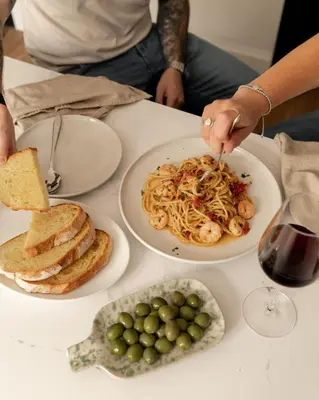 a table with two plates of food and a glass of wine at Moment Blythswood St in Glasgow