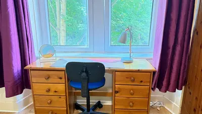 a desk with a chair in front of a window at Glasgow One Bedroom Flat close to city centre and all amenities in Glasgow