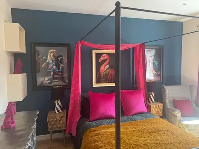 a bedroom with a canopy bed with pink pillows at Jett Joy in Moffat