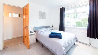 a small bedroom with a bed and a window at Stag's View Lodge in Edinburgh