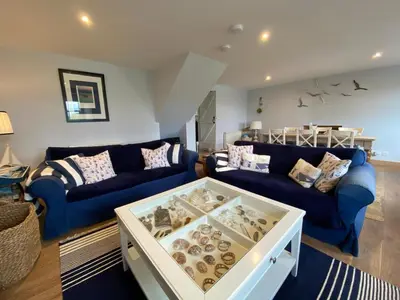 a living room with two blue couches and a table with donuts at Smithy House in Crinan