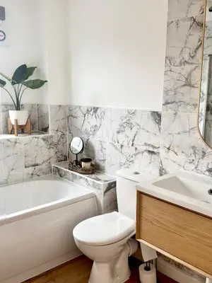a bathroom with a toilet and a tub and a sink at Almondvale Apartment in Livingston