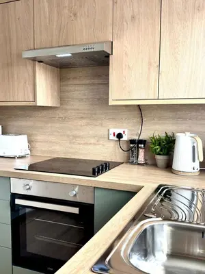 a kitchen with a sink and a stove top oven at Almondvale Apartment in Livingston