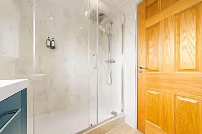 a shower with a glass door in a bathroom at Bright & Modern 3-Bed House Next To Glasgow Airport in Abbotsinch