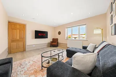 a living room with a couch and a tv at Bright & Modern 3-Bed House Next To Glasgow Airport in Abbotsinch