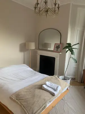 a bedroom with a bed with a mirror and a plant at Rachael's House in Moffat