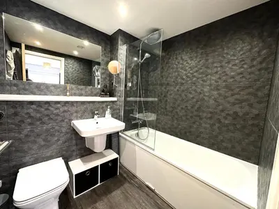 a bathroom with a sink and a toilet and a bath tub at The Clyde Retreat, 2 Bedrooms in Glasgow
