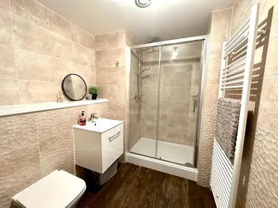 a bathroom with a shower and a toilet and a sink at The Clyde Retreat, 2 Bedrooms in Glasgow