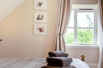a bedroom with a bed with a window and a pile of towels at 2 Bed in Methven oc-c32362 in Methven