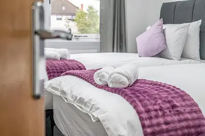 a couple of beds with towels on top of them at Super Prime The City Residence in Dunfermline