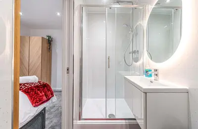 a white bathroom with a shower and a sink at Super Prime The City Residence in Dunfermline