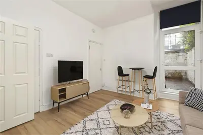 a living room with a television and a table at Haymarket Edinburgh Flat Sleeps 4 in Edinburgh