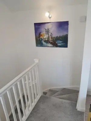 a staircase in a house with a painting on the wall at Detached Home in Bishopton in Bishopton