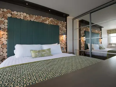 a bedroom with a large bed with a green headboard at The Waterside Hotel & Spa in Seamill