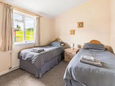 two beds in a room with a window at Chalet Loch Side Lodge 5 by Interhome in Kinross