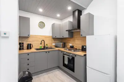 a kitchen with white cabinets and a white refrigerator at Sleek Canalside Stay in Edinburgh in Edinburgh