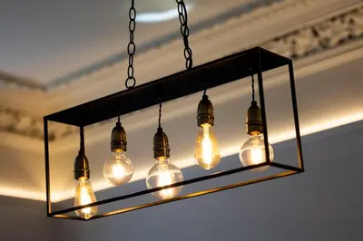 a chandelier with light bulbs hanging from a ceiling at The Burnbank Experience in Glasgow