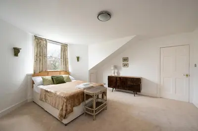a bedroom with a bed and a dresser and a window at Elegant Town house in Edinburgh in Moffat