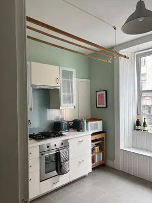 a kitchen with white cabinets and a stove top oven at Modern One Bed Flat, Historic Old Town Edinburgh in Edinburgh