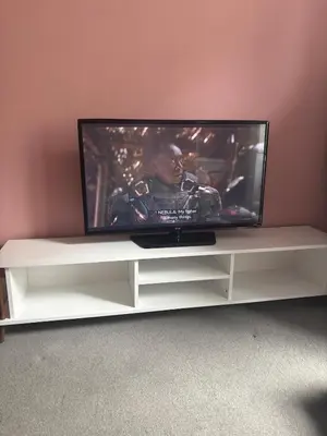 a flat screen tv sitting on a white entertainment center at Modern One Bed Flat, Historic Old Town Edinburgh in Edinburgh