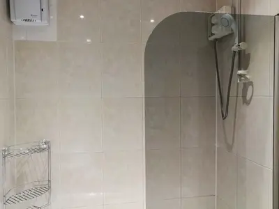 a bathroom with a shower with a shower head at Glasgow Property New City Rd in Glasgow