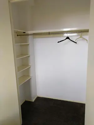 a walk in closet with white walls and shelves at Glasgow Property New City Rd in Glasgow