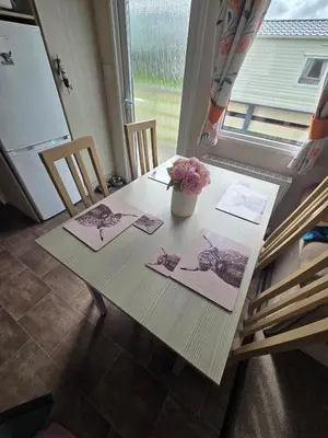 a table with a vase of flowers on top of it at Lovely Caravan number 96 at Three Lochs Holiday Park in Kirkcowan