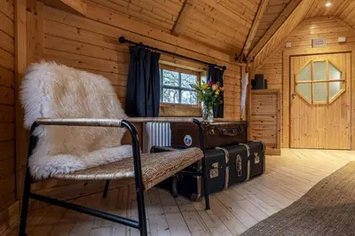 a room with a bench and a window in a cabin at Carnethy Cabin in Kirknewton