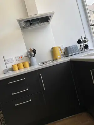 a kitchen with black cabinets and a sink at Foundry Street Apartment 3 - Dunfermline City Centre in Dunfermline