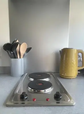 a stove top with a pot on a counter at Foundry Street Apartment 3 - Dunfermline City Centre in Dunfermline