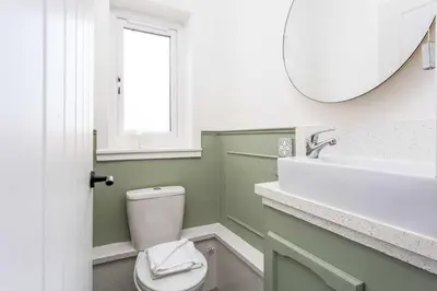 a bathroom with a toilet and a sink and a mirror at No15 Ellis House - Donnini Apartments in Kilmarnock