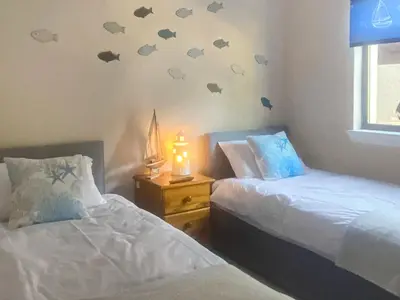 a bedroom with two beds with bats on the wall at Riverside Cottage in Lamlash