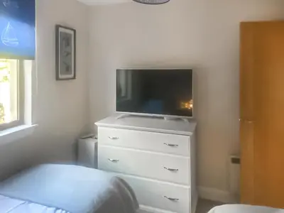 a bedroom with a tv on top of a dresser at Riverside Cottage in Lamlash