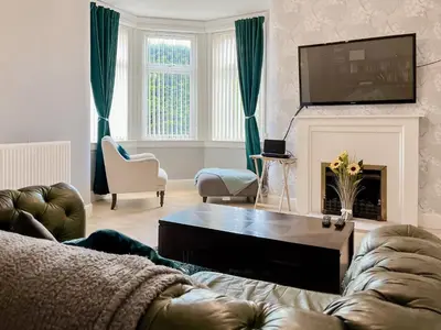 a living room with a couch and a tv at Homely Base in Crossgates