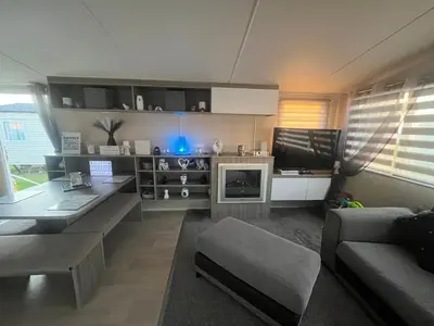 a living room with a couch and a tv at the heaths caravan hire Craig Tara in Minishant