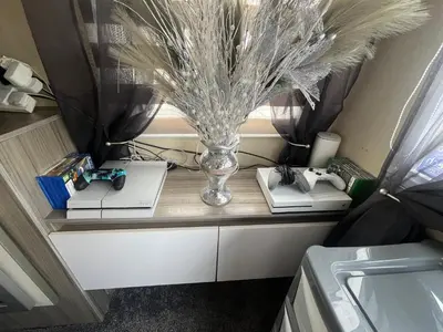 a table with a vase and books on it at the heaths caravan hire Craig Tara in Minishant