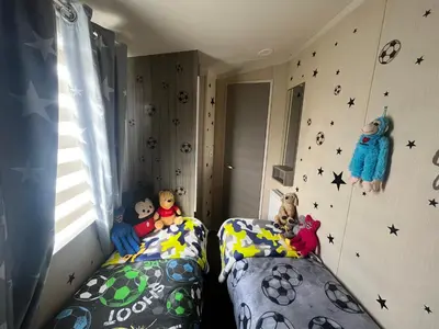 a bedroom with two beds with stuffed animals on them at the heaths caravan hire Craig Tara in Minishant