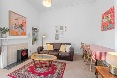 a living room with a couch and a table at Cosy 1 Bedroom Apartment next to Fountain Park - Edinburgh in Edinburgh