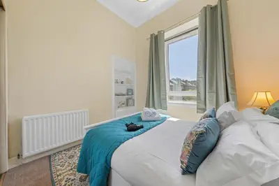 a bedroom with a large bed with a window at Cosy 1 Bedroom Apartment next to Fountain Park - Edinburgh in Edinburgh