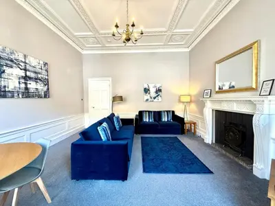 a living room with a blue couch and a fireplace at New Town luxury 1 bed apartment in Edinburgh