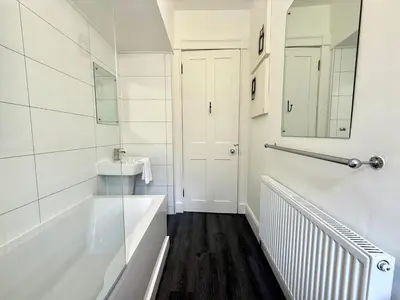 a white bathroom with a tub and a sink at New Town luxury 1 bed apartment in Edinburgh